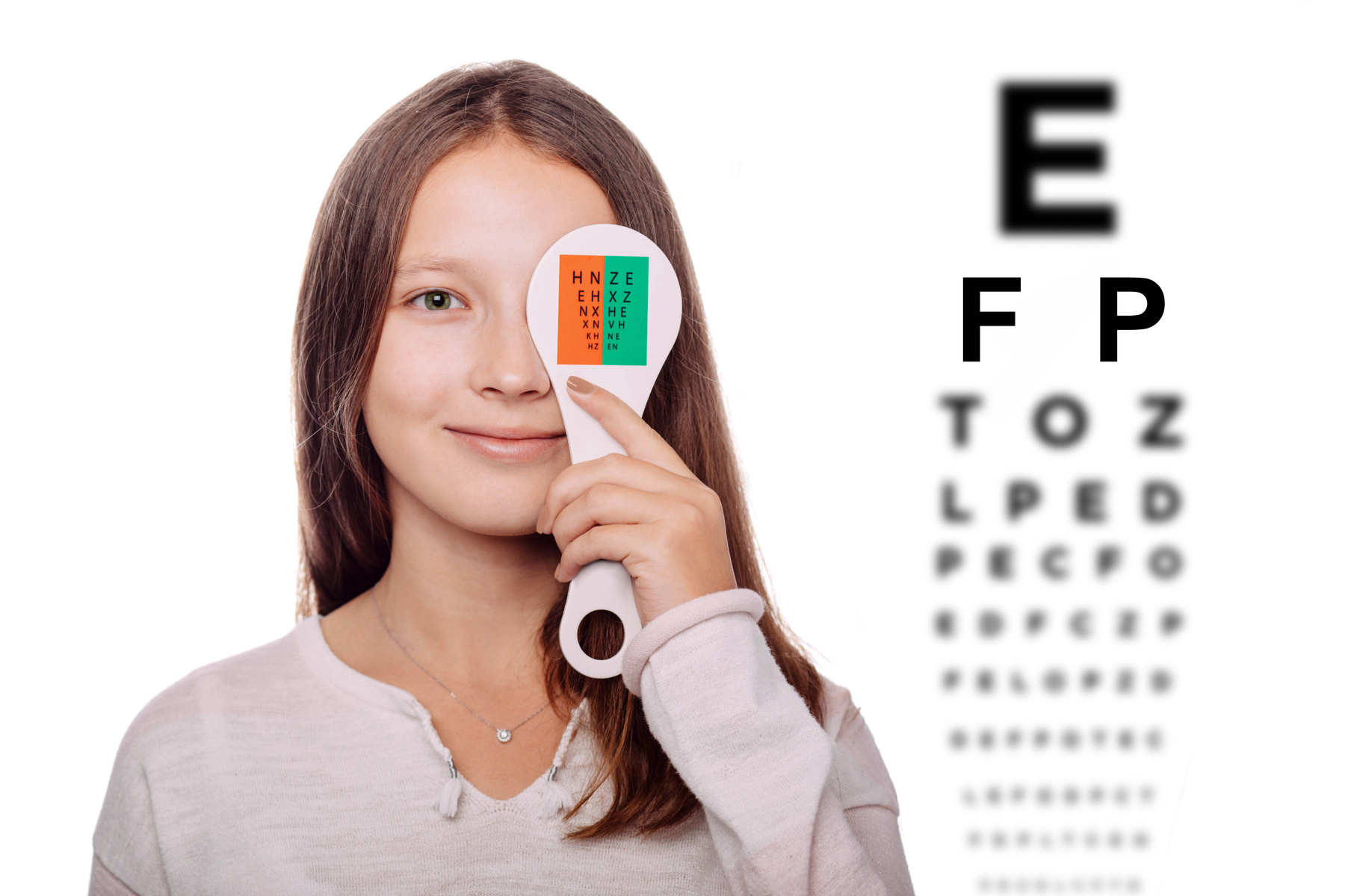 Teenage girl having eye exam with one eye covering excellent pediatric eye exams from Specs Eye Care in Chattanooga TN